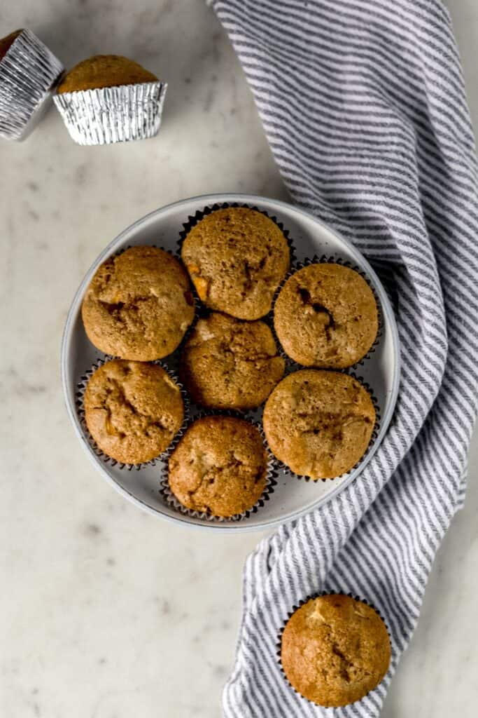 overhead view peach cobbler muffins in large bowl next to napkin