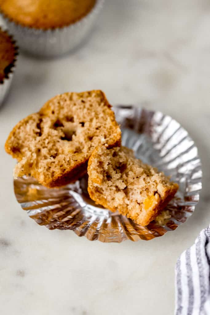 peach cobbler muffin cut in half with a bite in one half