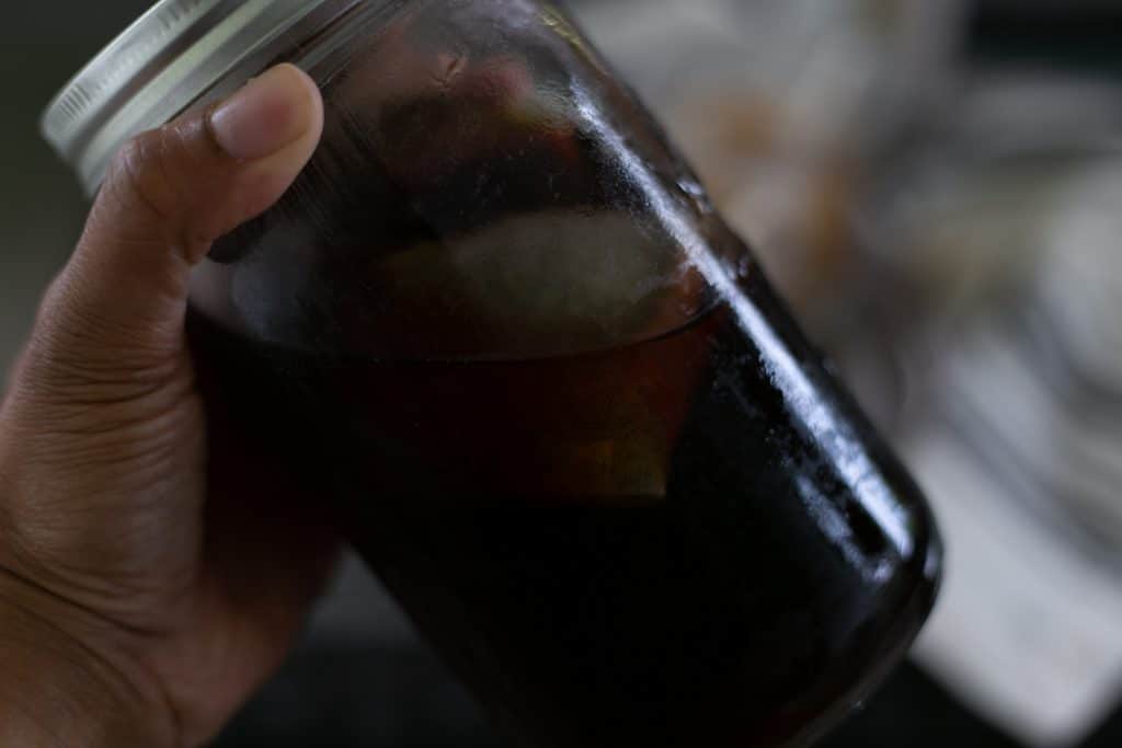 Hand Holding Homemade Cold Brew Coffee in a jar