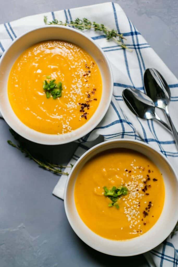 Overhead view of Sweet Potato Miso Soup in two bowls with napkin and spoons