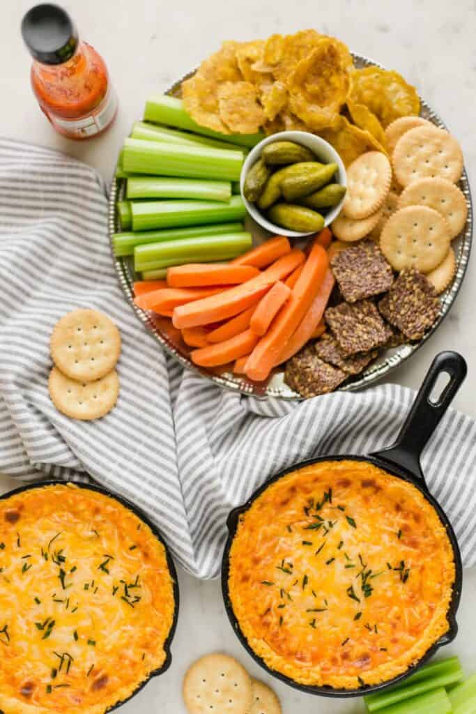 buffalo chicken dip recipe with hot sauce, platter, and dip in mini skillets