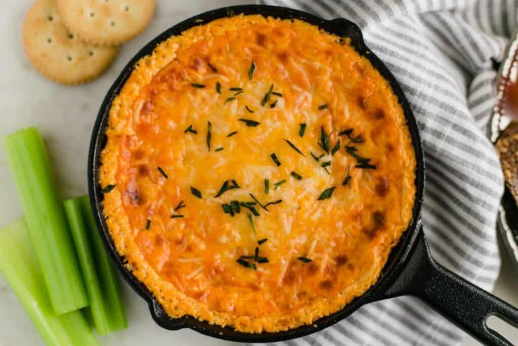 overhead shot of Buffalo Chicken Dip Recipe with a napkin, celery, and crackers