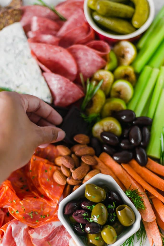 hand grabbing item off cheese board 