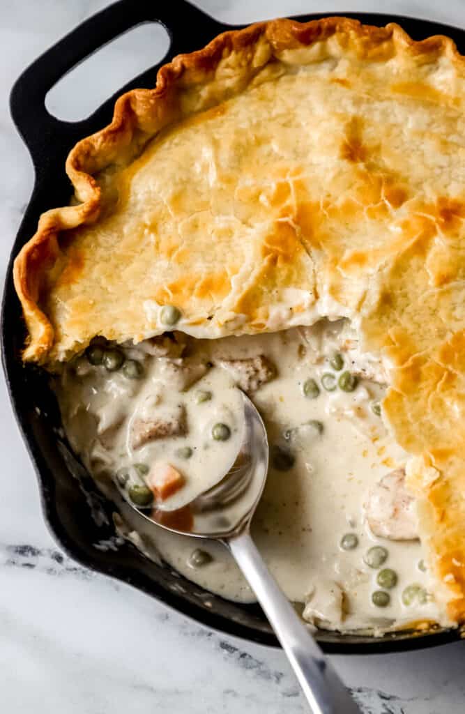 overhead view of finished pot pie with pieces missing and spoon in it