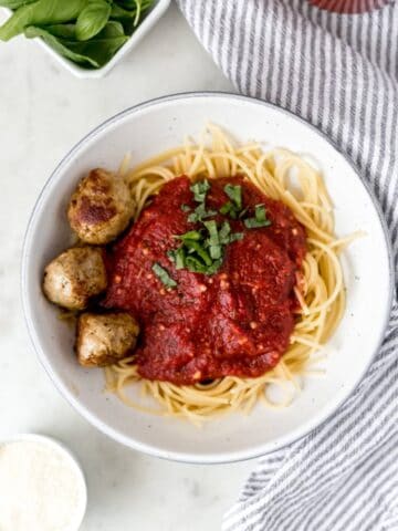 overhead view of plate of pasta beside a cloth napkin