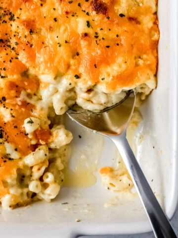 Close up overhead view of baked macaroni with serving spoon in it.