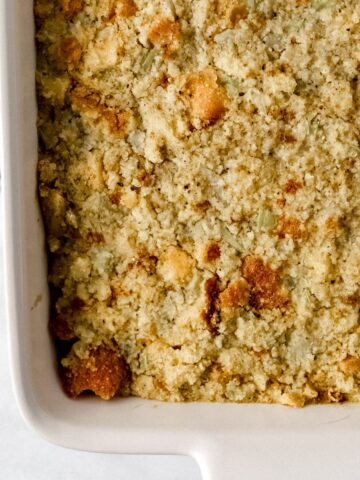 Finished cornbread dressing in white rectangle baking dish.