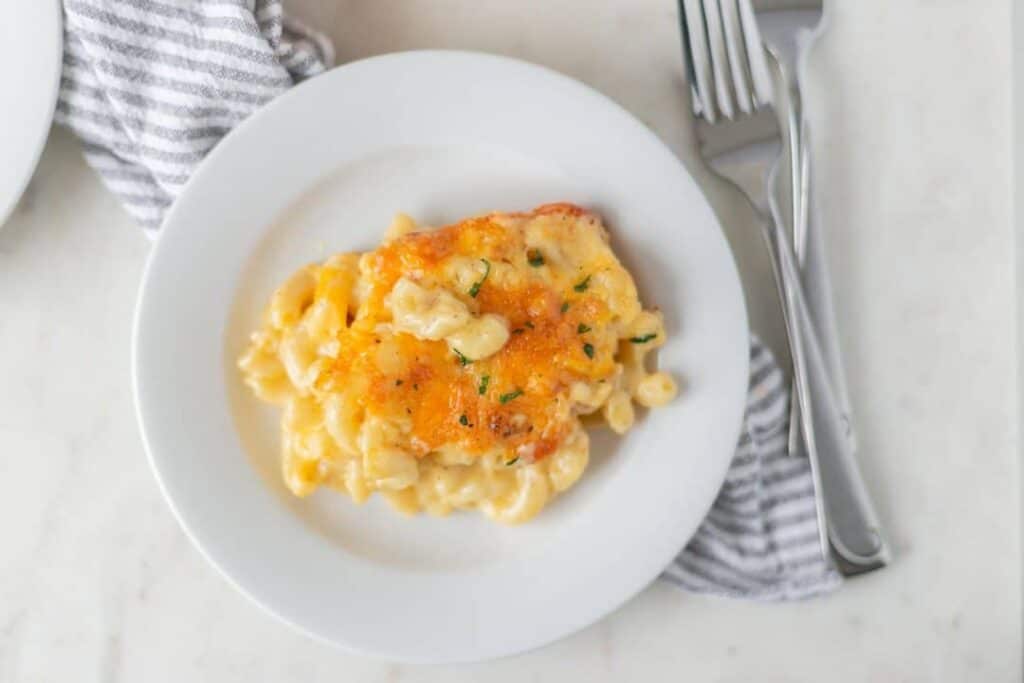 Southern Mac and Cheese portion on round white plate with fork and napkin