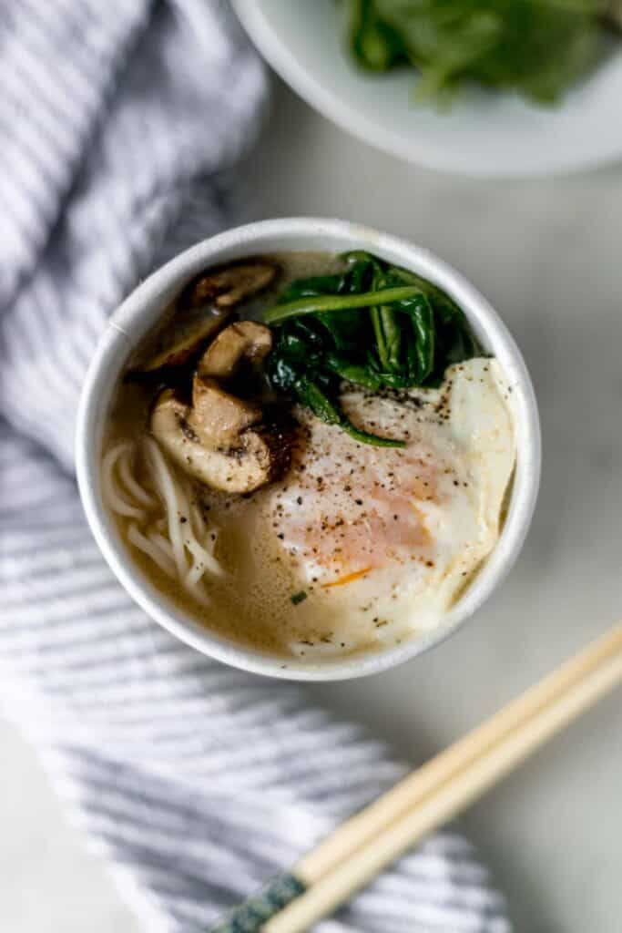 close up overhead view instant ramen with egg, mushrooms, spinach