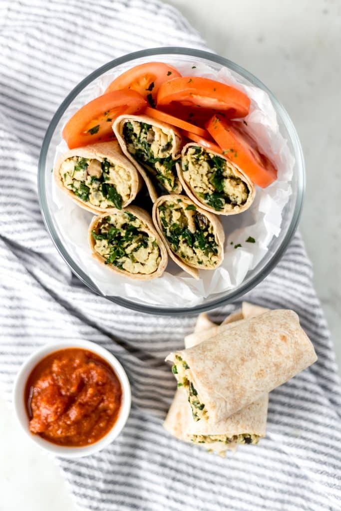 overhead view of breakfast burritos recipe in a bowl with tomato slices