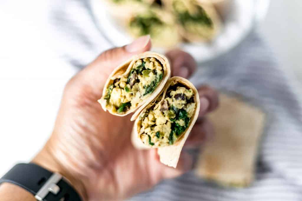 hand holding breakfast burritos recipe