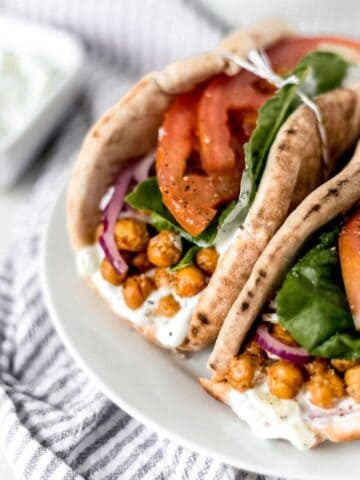 Close up view of finished gyros on white plate.