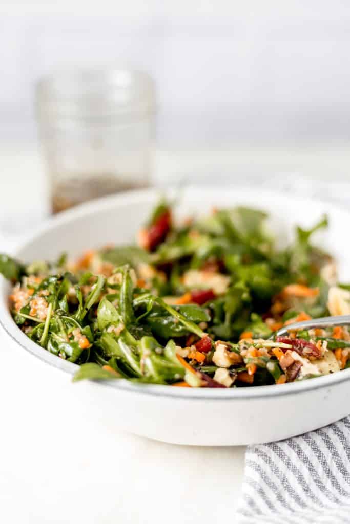 close-up side view of bowl of salad with a fork in it