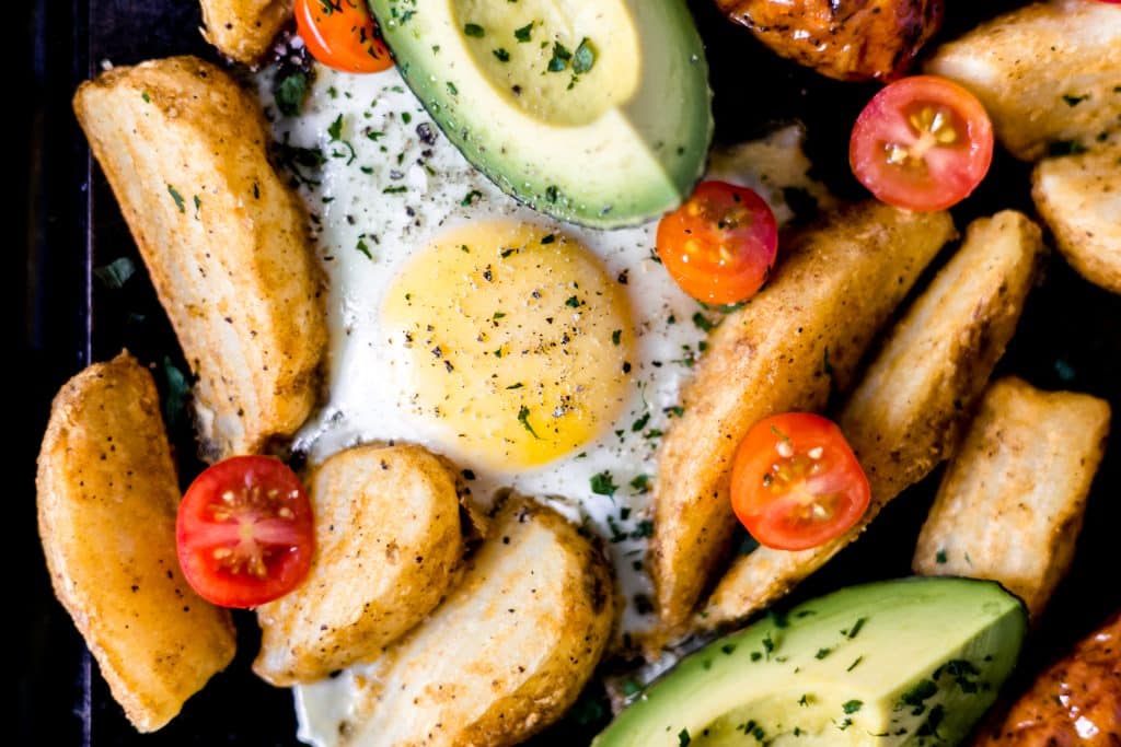close-up photo of sheet pan breakfast bake egg, potatoes, avocado, tomatoes