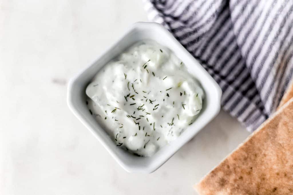 fresh tzatziki sauce in a dish topped with dill