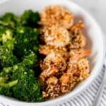 close up side view of bowl of cooked shrimp and broccoli