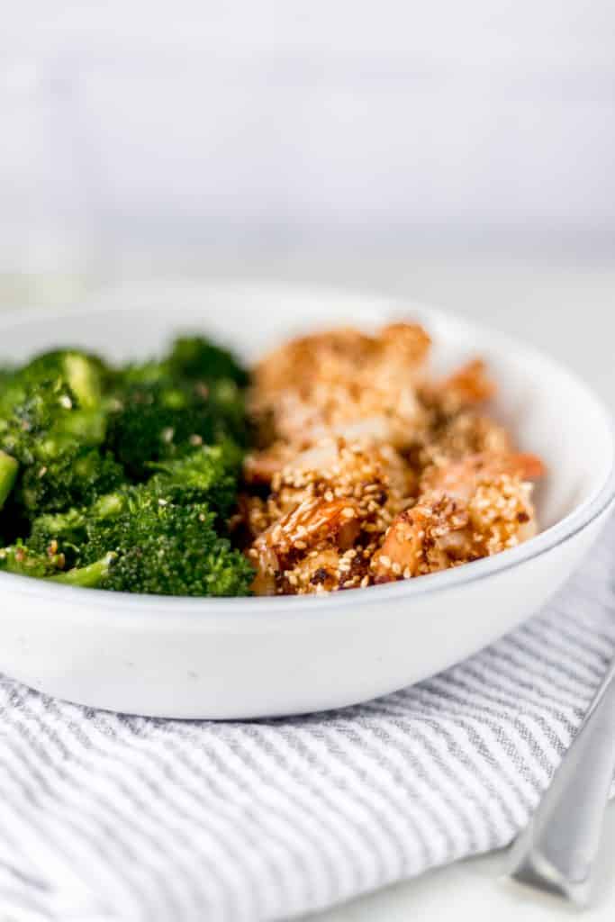 close-up side view of sesame shrimp and broccoli in a bowl