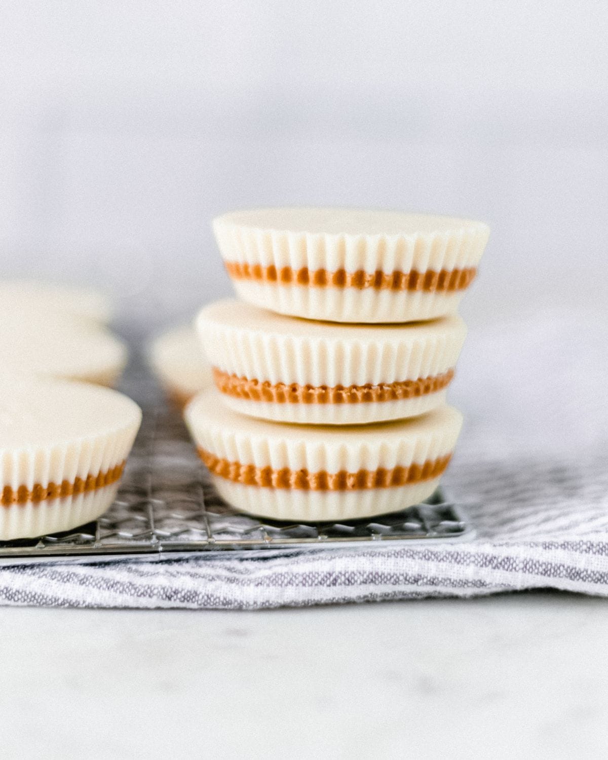 Close up side view of finished peanut butter cups stacked on top of each other.