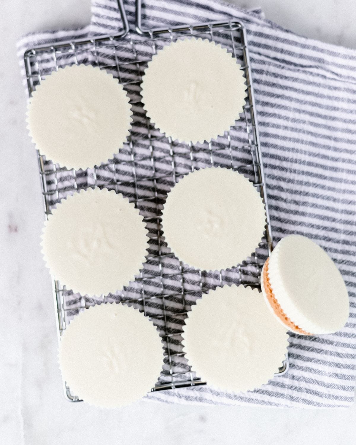 Overhead view of peanut butter cups on grate on top of cloth napkin.