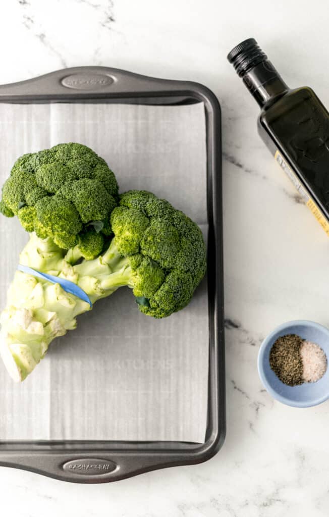 ingredients to make roasted broccoli on marble surface. 