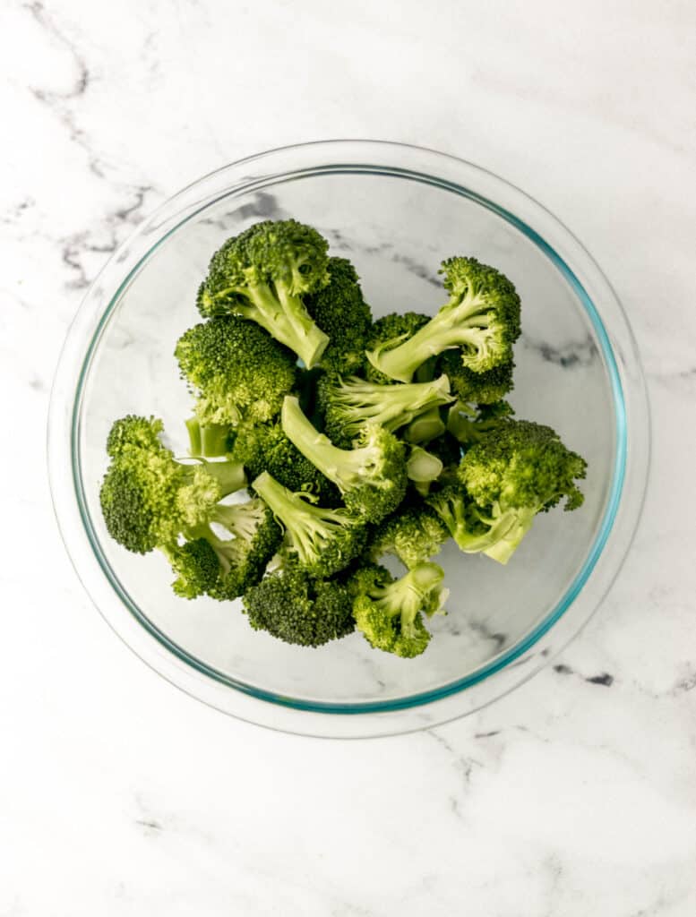 fresh cut broccoli in large glass bowl 