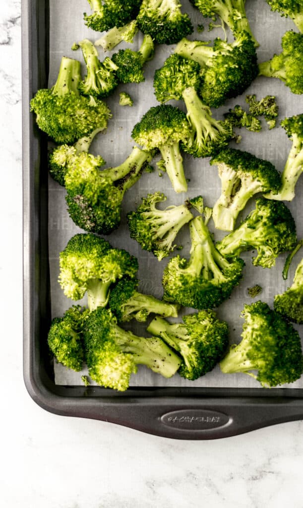 fresh broccoli on parchment lined baking sheet. 