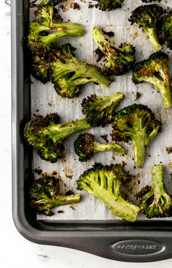 roasted broccoli on oven lined parchment baking sheet. 