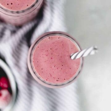 overhead view strawberry smoothie in glass with straw