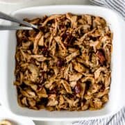 Overhead view of pulled pork in baking dish.