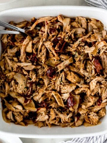 Overhead view of pulled pork in baking dish.