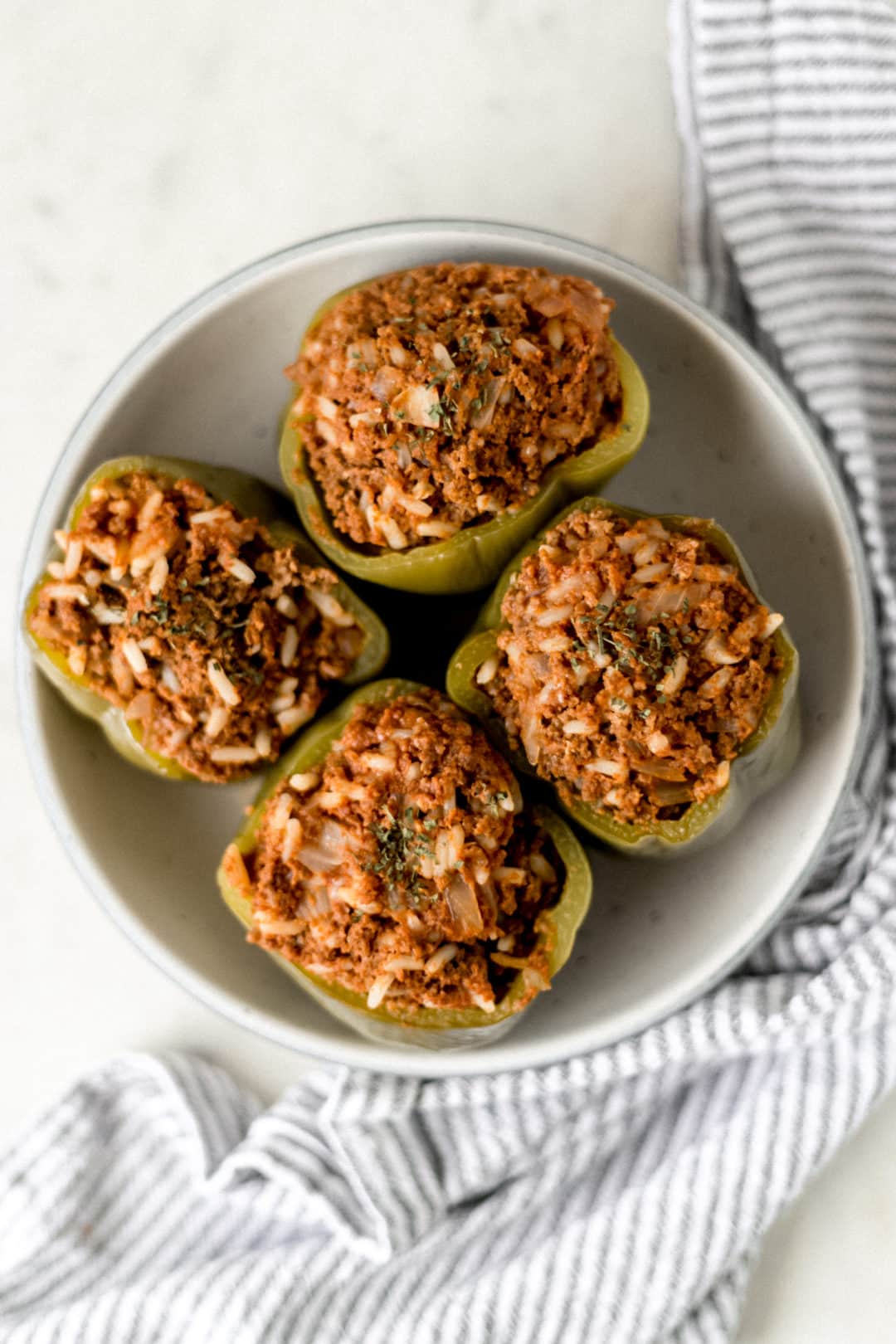 four instant pot stuffed peppers inside a bowl with a napkin