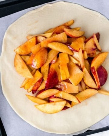 Peach mixture added to dough on parchment lined baking sheet.