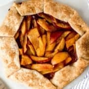 Overhead view of baked galette by knife and cloth napkin.