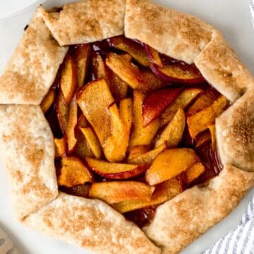 Overhead view of baked galette by knife and cloth napkin.