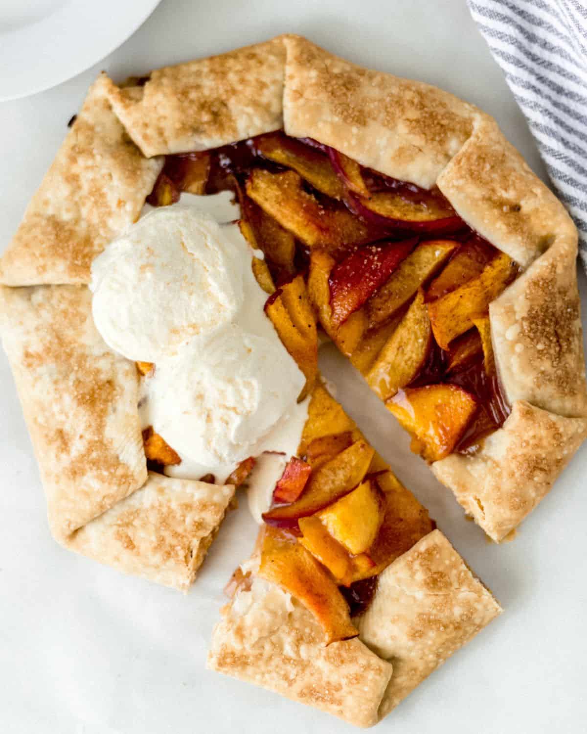 Finished galette with a piece cut out of it and topped with ice cream.