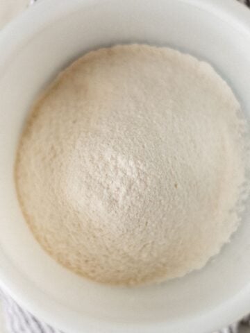 Overhead view of self-rising flour in white bowl.