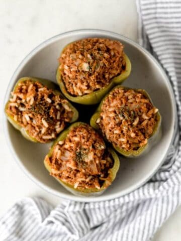 four instant pot stuffed peppers inside a bowl with a napkin