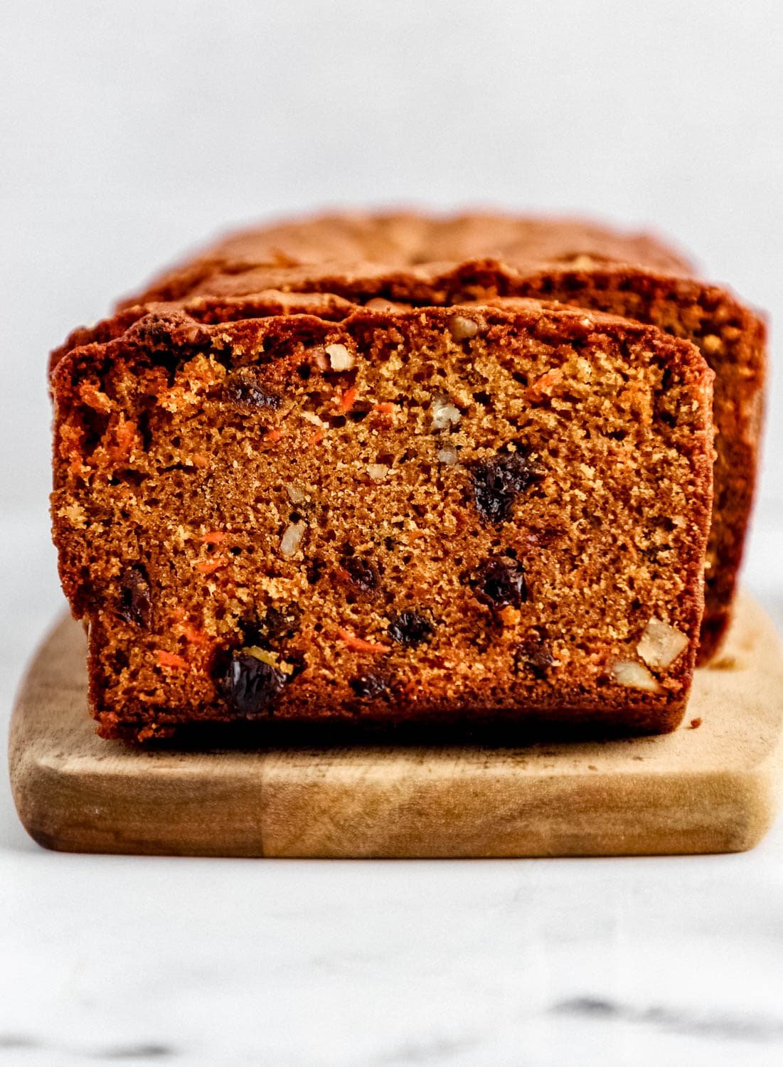 Close up front view of sliced bread on wooden cutting board.