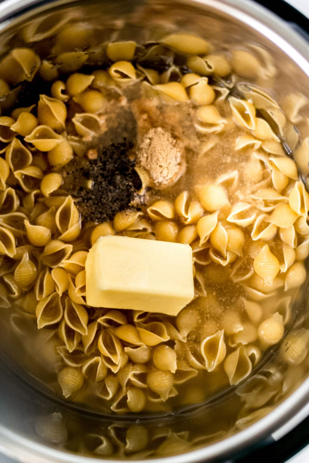 pasta with seasoning and butter in a pressure cooker/instant pot