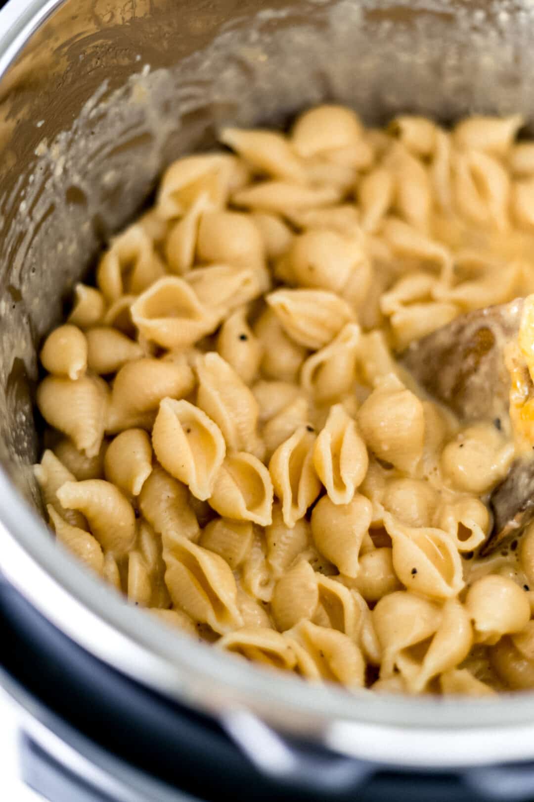 finished recipe for pressure cooker mac and cheese in an instant pot with wooden spoon