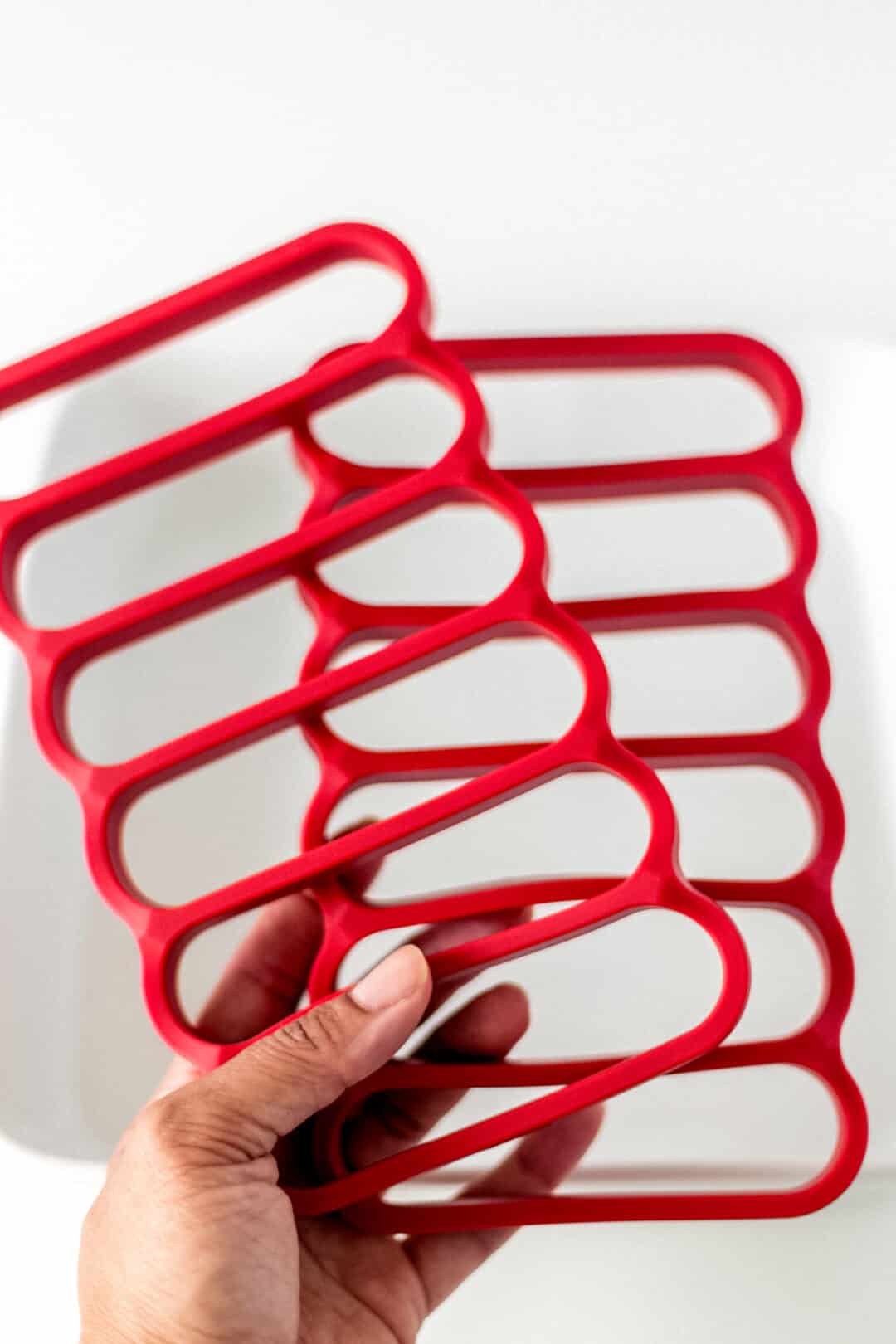 hand holding red plastic rack inserts for turkey