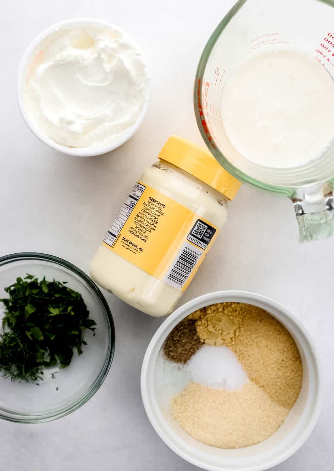 Overhead view of ingredients needed to make dressing in separate containers. 