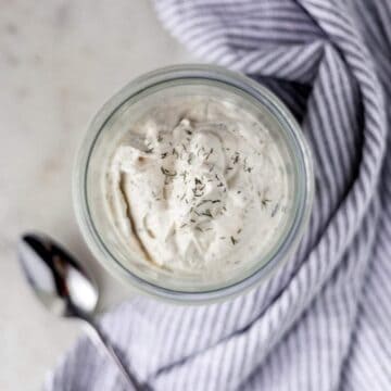 keto salad dressing in a jar next to a napkin and a spoon