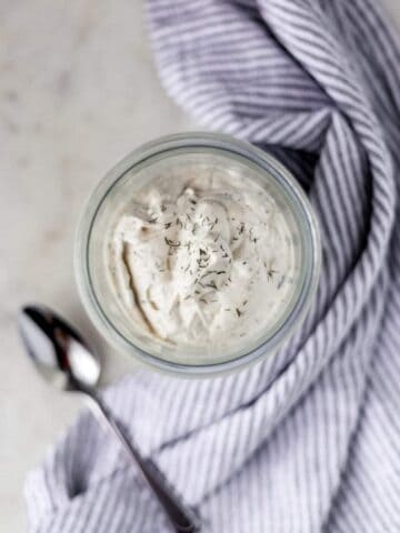 keto salad dressing in a jar next to a napkin and a spoon