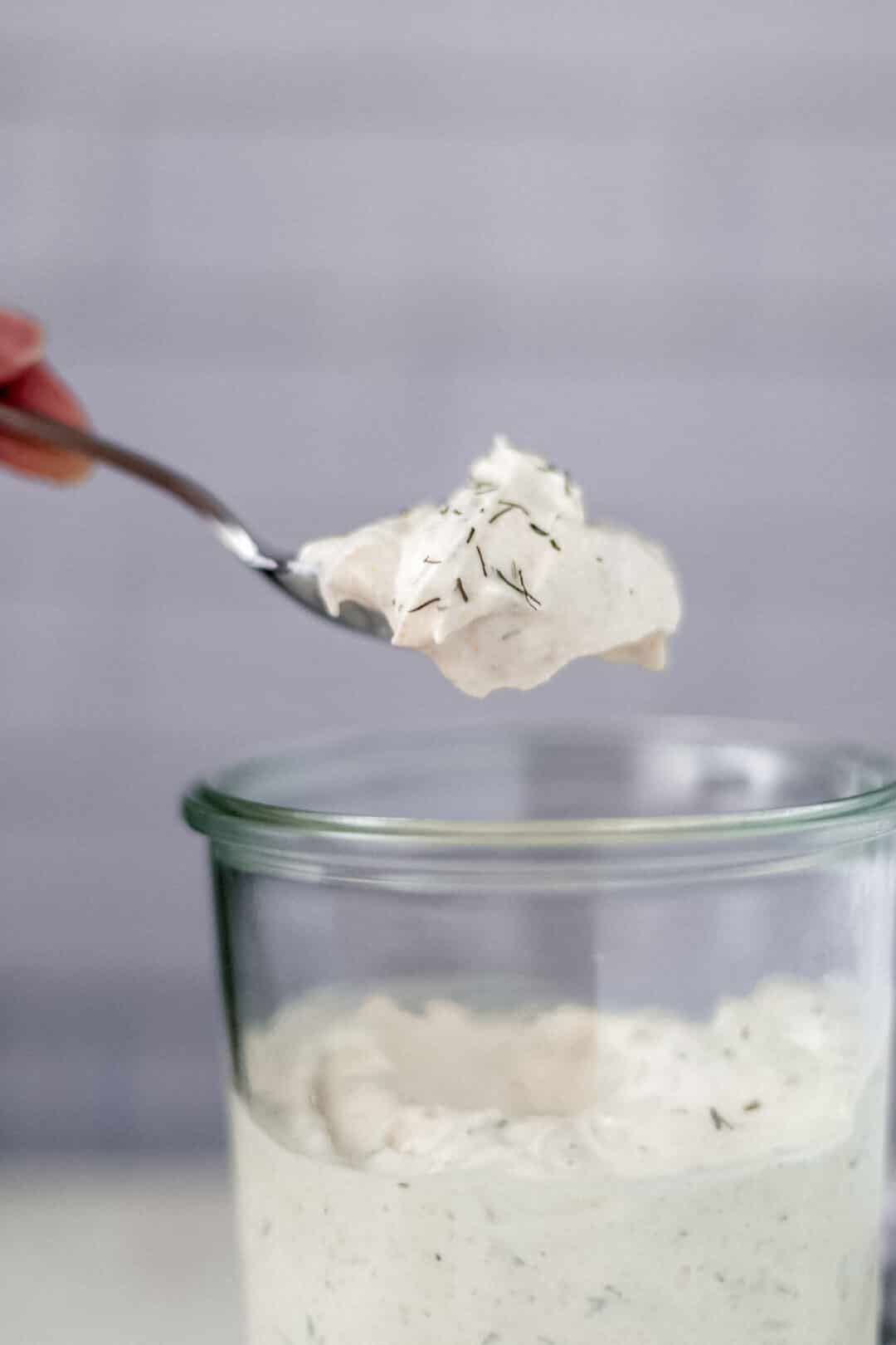 hand holding spoon of homemade low carb ranch salad dressing