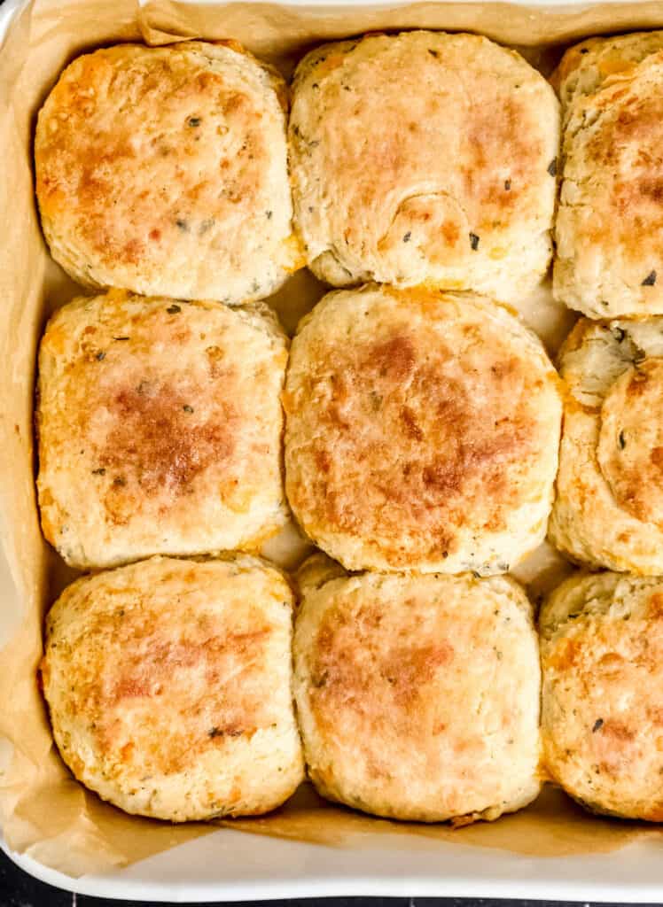 Close up view of biscuits in parchment lined baking dish.