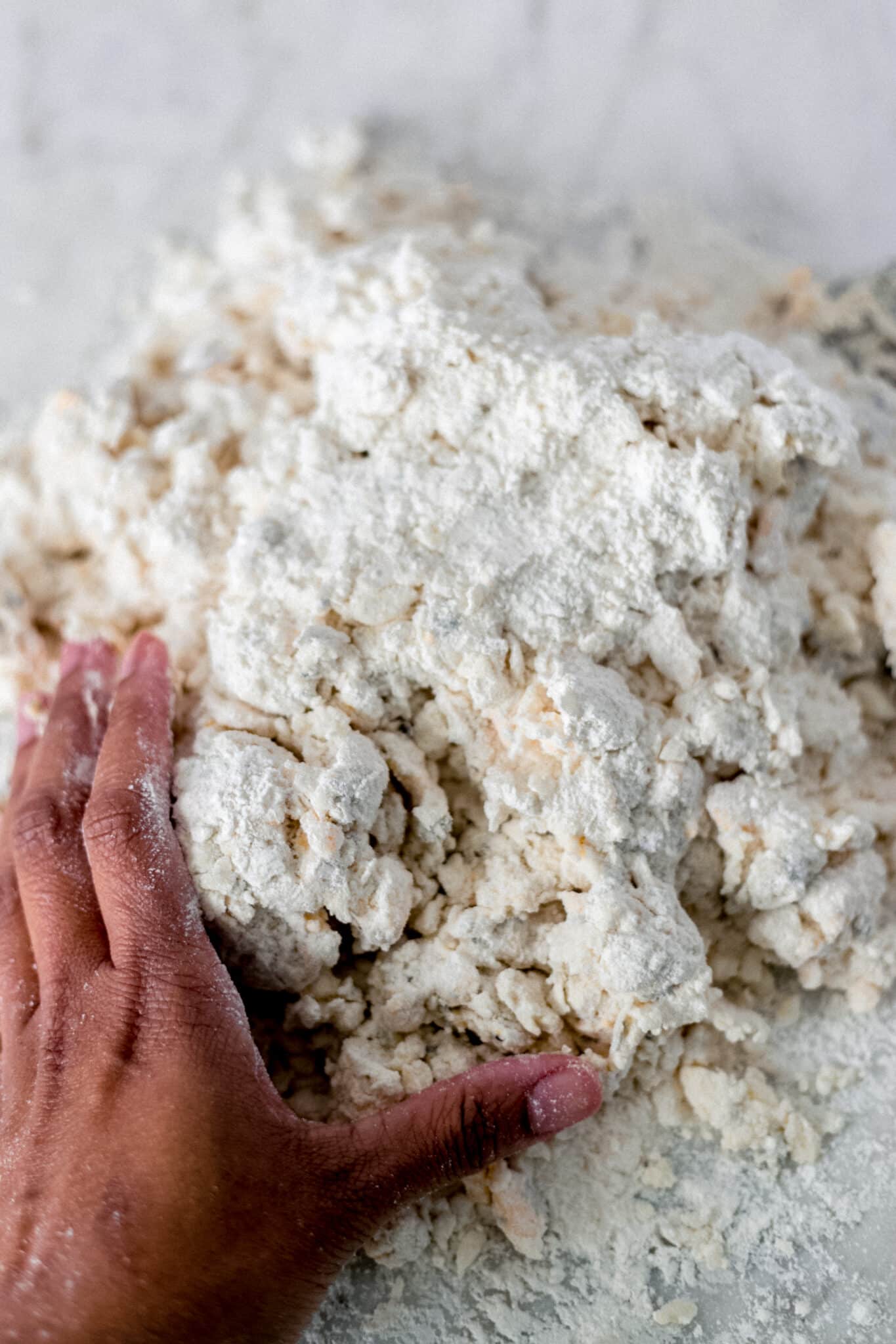 hand pressing biscuit dough out on counter top