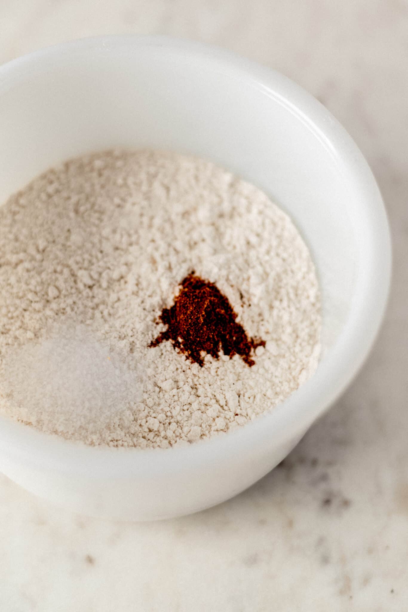 flour, nutmeg, and salt in a white mixing bowl