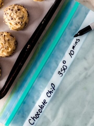 Close up of cookie dough on sheet pan by freezer bag and sharpie.