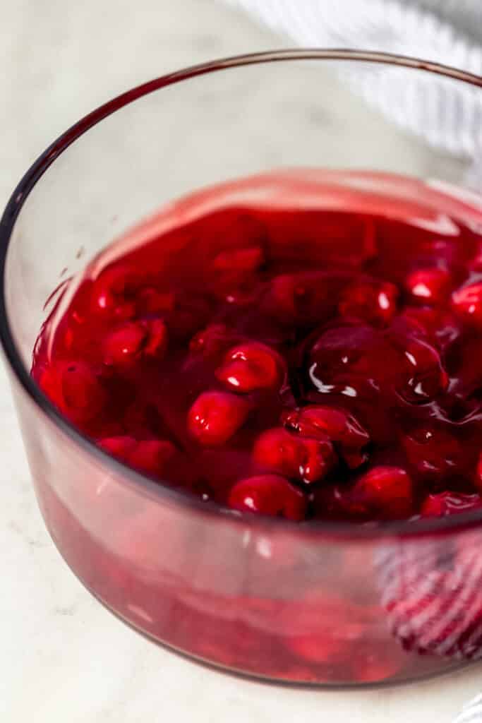 cherry pie filling spread in the bottom of a glass dish for chocolate cherry dump cake